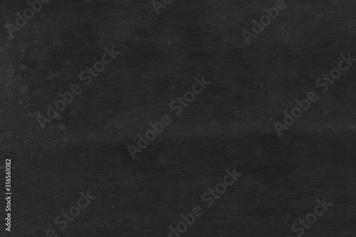 Cardboard black abstract texture close-up. Dark old paper background. Grunge concrete wall. Vintage blank wallpaper.