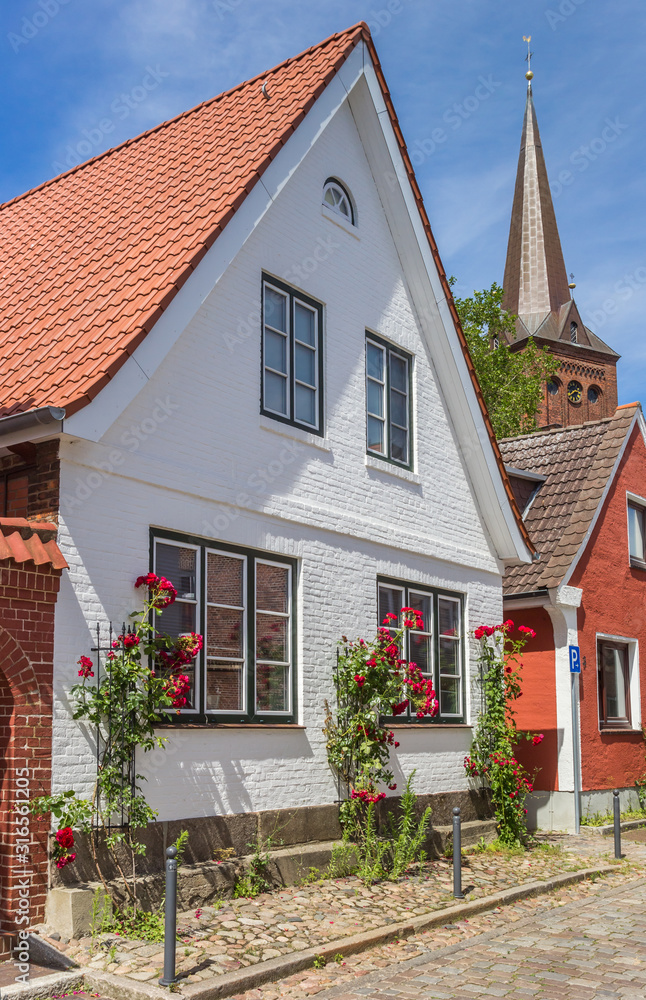 White house with red flowers in Plon, Germany