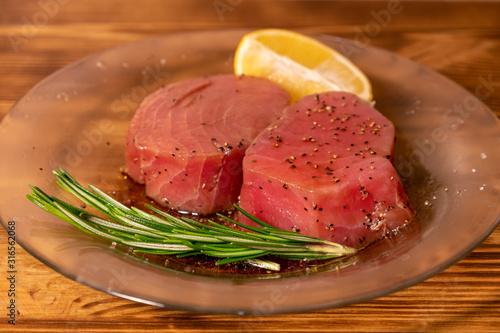 Fresh raw tuna fillet for steak on plate. Tasty fish dinner. Ingredients for cooking