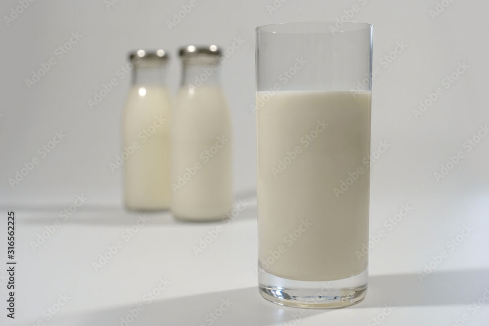 Milk in a glass on a gray background close-up. Milk product. Milk in a glass on a gray background close-up. Milk product.