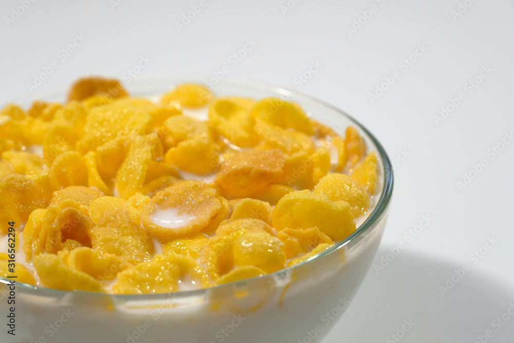 Corn flakes in a bowl on a gray background close-up. Corn flakes in a bowl on a gray background close-up.