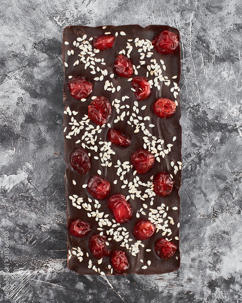 Obraz premium Handmade chocolate bar with cherry and sesame filling.