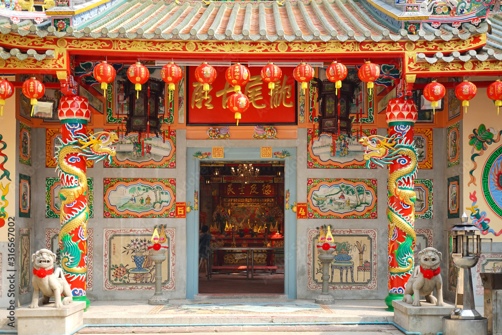 Chinese shrine. A beautiful architectural details of the Chinese shrine's entrance, decorated with golden dragon on both side. Chinese character means name of the shrine.