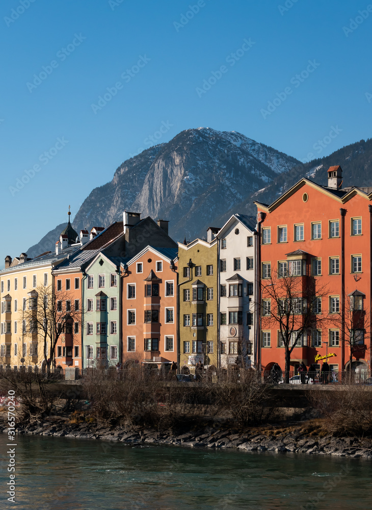 Iconic colorful austrian houses on a clear sunny day with a big mountain on the background