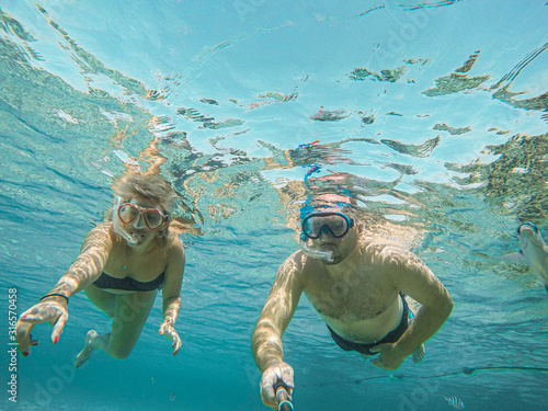 Young couple snorkeling selfie underwater camera on the coral reef in ocean of Egypt Hurghada travel concept vacation