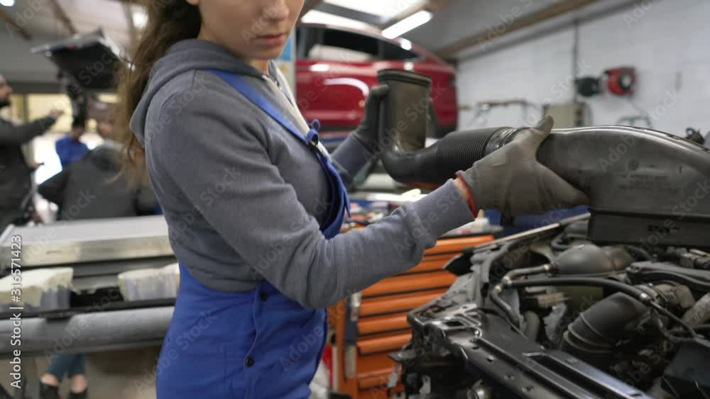 Young woman apprentice working in mechanics workshop Young woman apprentice working in mechanics workshop