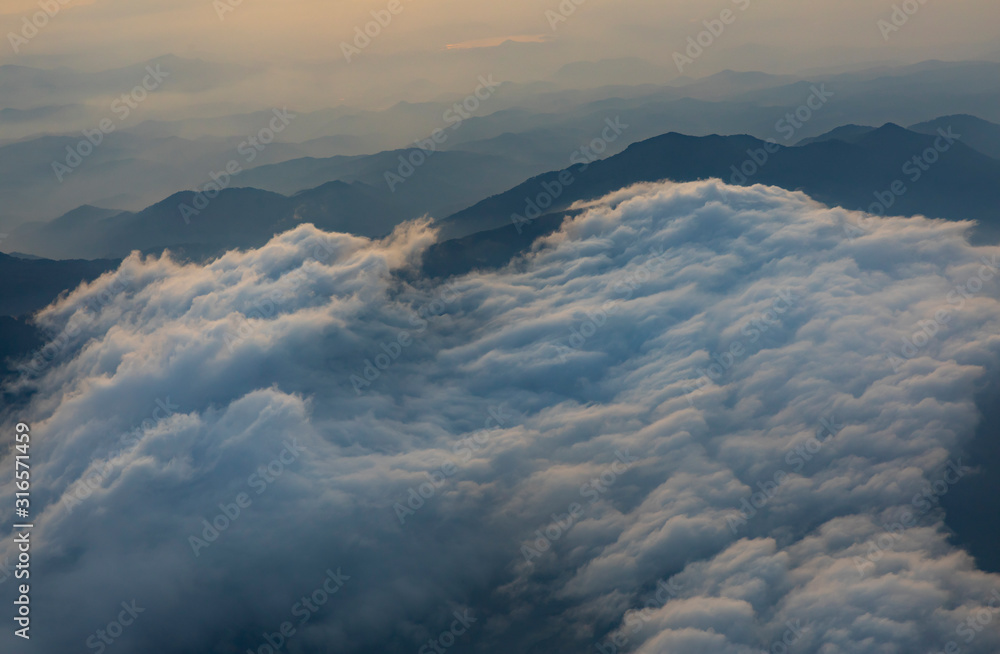 Flying over central highlands of Vietnam at dawn near the city of Da Lat. Clouds and mist reveal the mountains below Flying over central highlands of Vietnam at dawn near the city of Da Lat. Clouds and mist reveal the mountains below