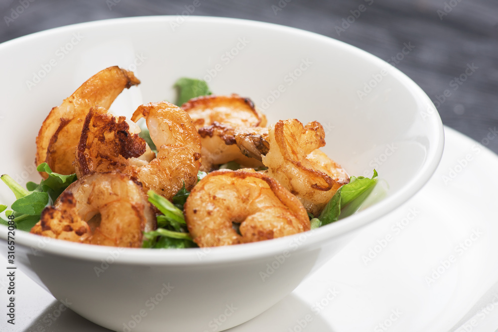 Fried shrimps with yogurt sauce and greens on plate Fried shrimps with yogurt sauce and greens on plate