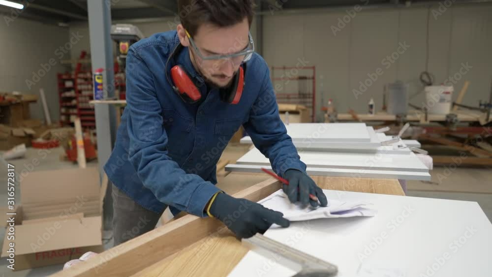Apprentice working wood in carpentry workshop Apprentice working wood in carpentry workshop