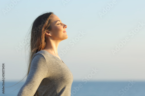 Woman breaths fresh air on the beach photo