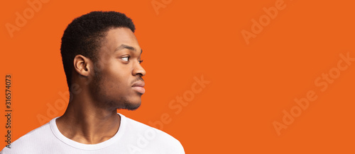 Side portrait of masculine afro guy looking at copyspace