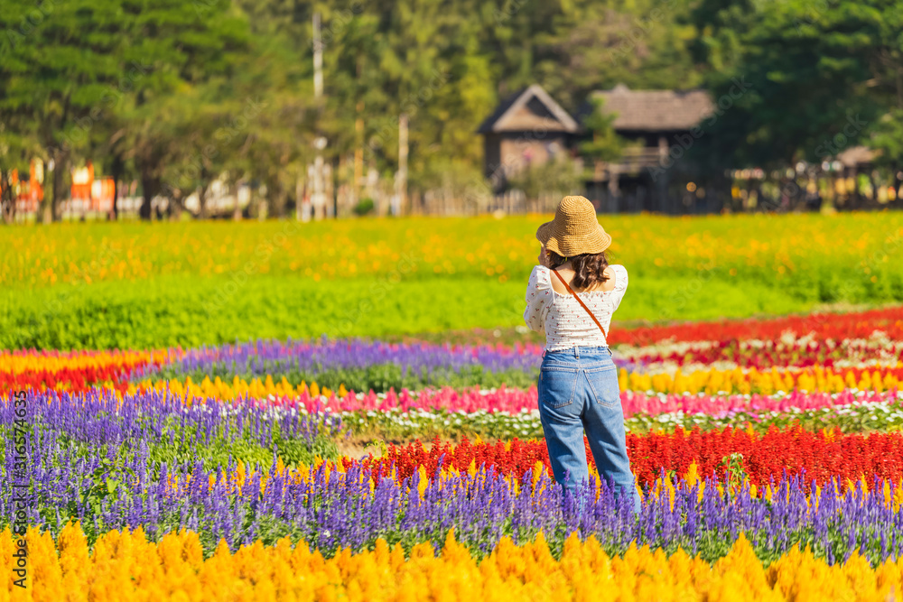 Young woman take a photo in the flowers garden Young woman take a photo in the flowers garden