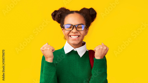 Cheering black school girl celebrating her triumph photo