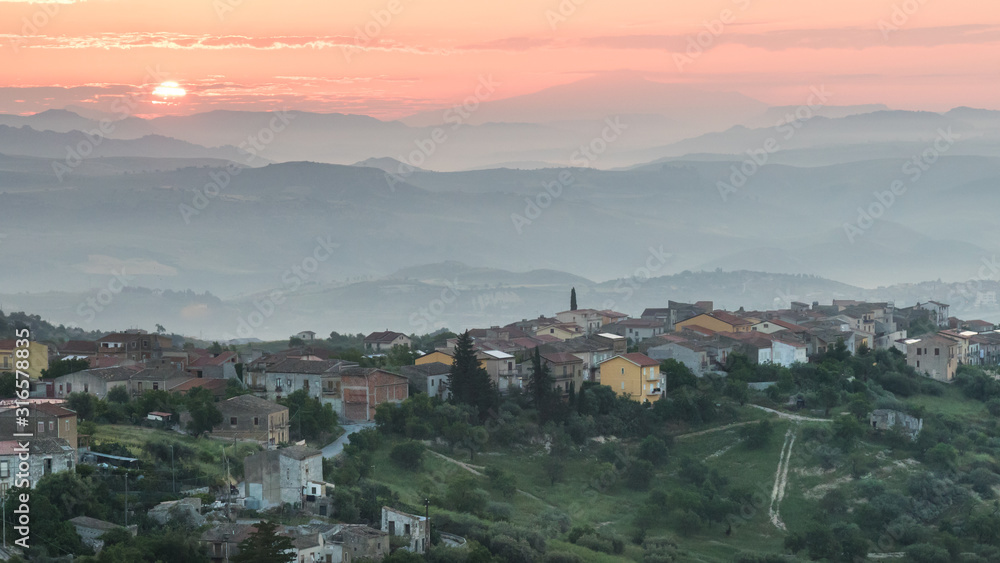 Sunrise over a village on a hill in sicily, italy