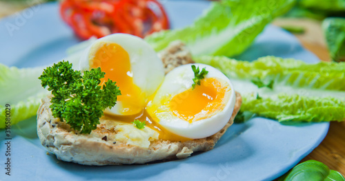 Soft boiled egg on the toasted multi seeded bread decorated with fresh parsley.