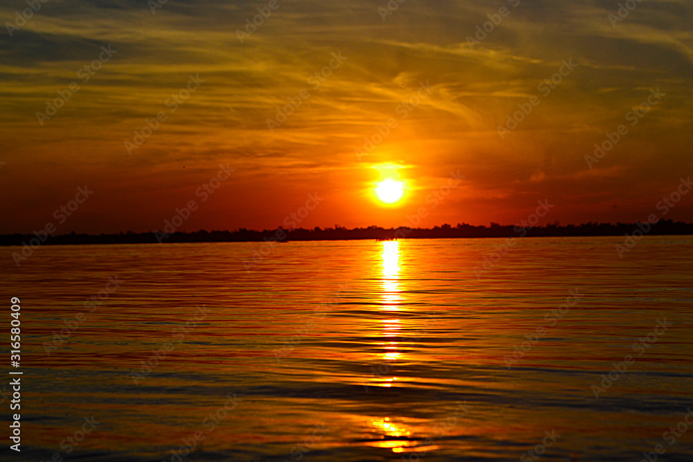 Fototapeta premium Atardecer con reflejo en el agua