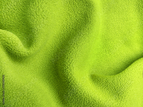 Crumpled warm green polar fleece fabric closeup photo