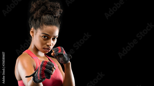 Panoramic photo of beautiful fighter woman over black background photo