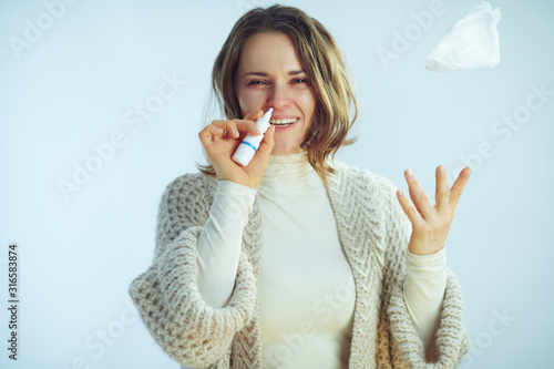 Fotografie woman using nasal spray and throwing up with napkin