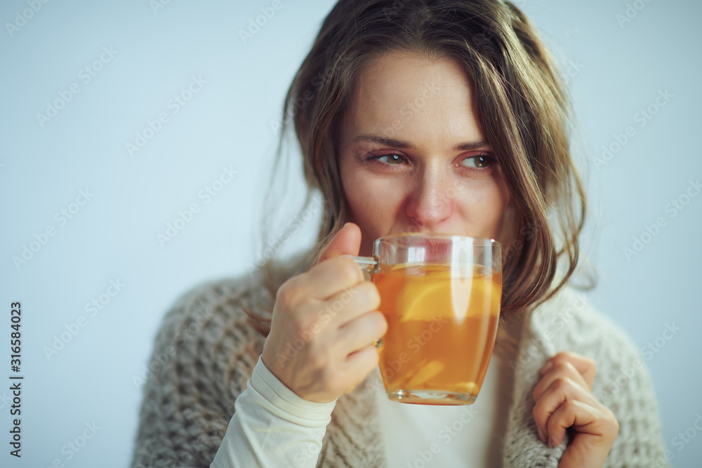housewife drinking cup of tea on winter light blue background housewife drinking cup of tea on winter light blue background