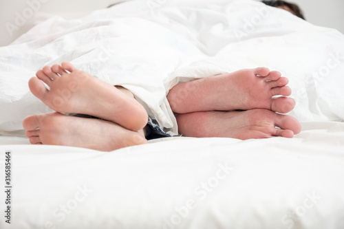 Close up conflict couple or angry couple feet on white bed in white background