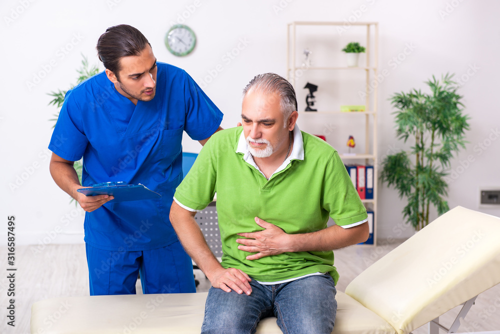 Fototapeta premium Old man visiting young male doctor gastroenterologist