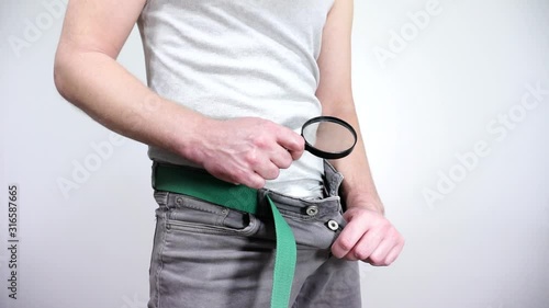 The guy looks in his pants with a magnifying glass.Small penis.