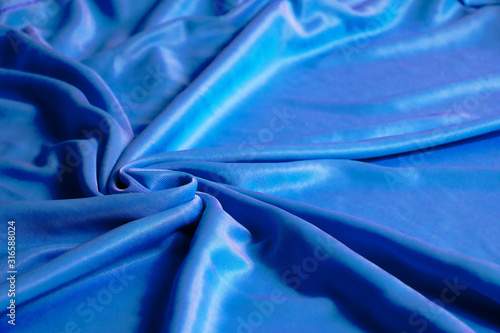 Texture, abstract background, silk blue fabric artistically laid out.