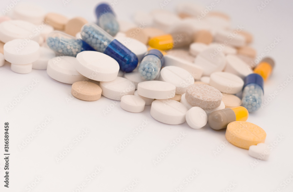 Heap of colorful pills in the shape of a heart, tablets and capsules on white background. Drug prescription for treatment medication health care concept, top view with copy space. Heap of colorful pills in the shape of a heart, tablets and capsules on white background. Drug prescription for treatment medication health care concept, top view with copy space.