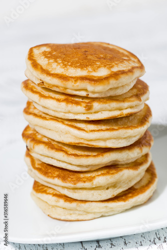 stack of delicious pancakes on white plate, vertical
