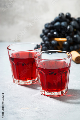 two glasses of red young wine on a gray background, vertical
