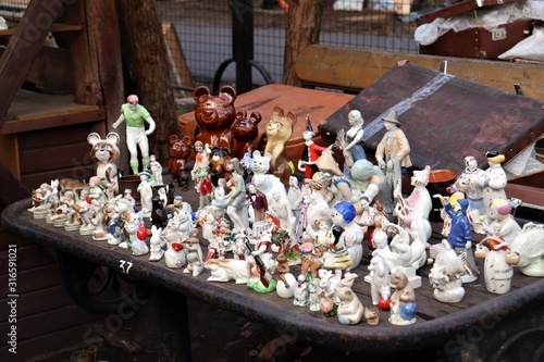 Flea market, porcelain figurines on an old cast-iron table. photo