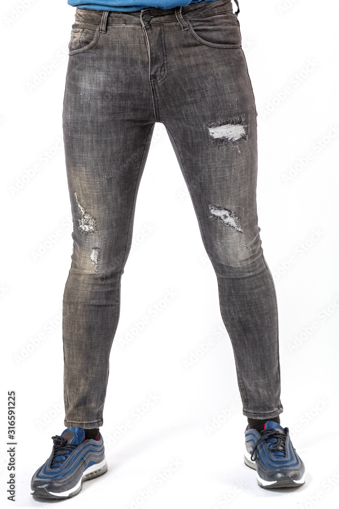 a man in fashionable black ripped jeans on a white background, black ripped jeans close-up a man in fashionable black ripped jeans on a white background, black ripped jeans close-up