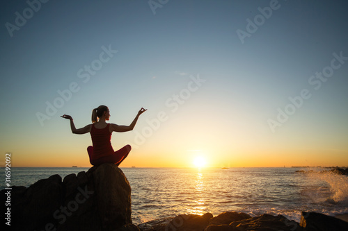 Young yoga woman on the beach amazing sunset..