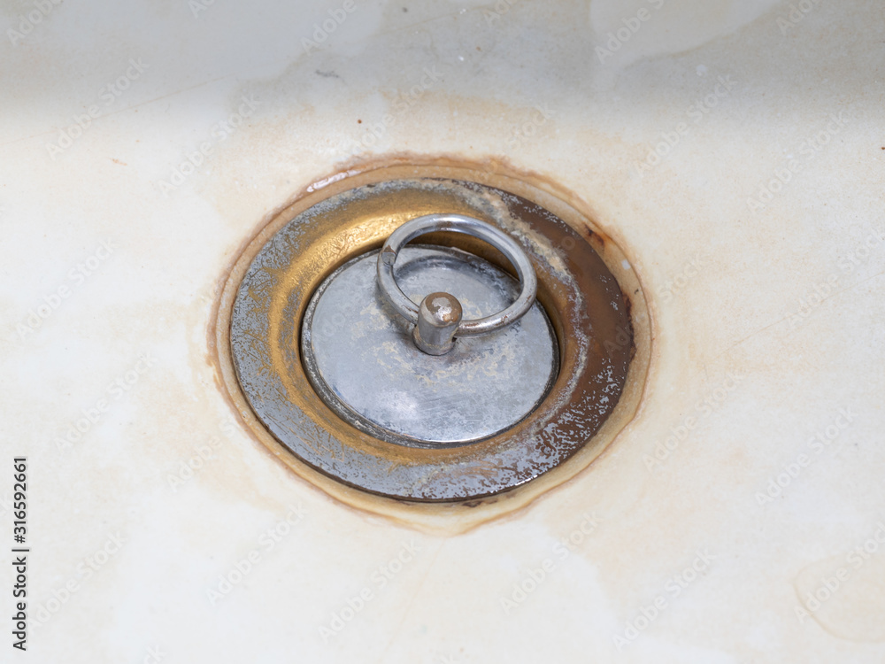 the drain in the bathroom is covered with a lid. dirty and rusty the drain in the bathroom is covered with a lid. dirty and rusty