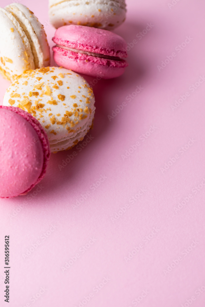 French pink and white macarons on pink pastel background. Top view with copy space for your text. French pink and white macarons on pink pastel background. Top view with copy space for your text.