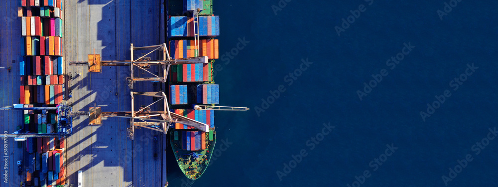 Aerial drone ultra wide top down photo of commercial container terminal with cranes loading shipment to tanker ships in Mediterranean port
