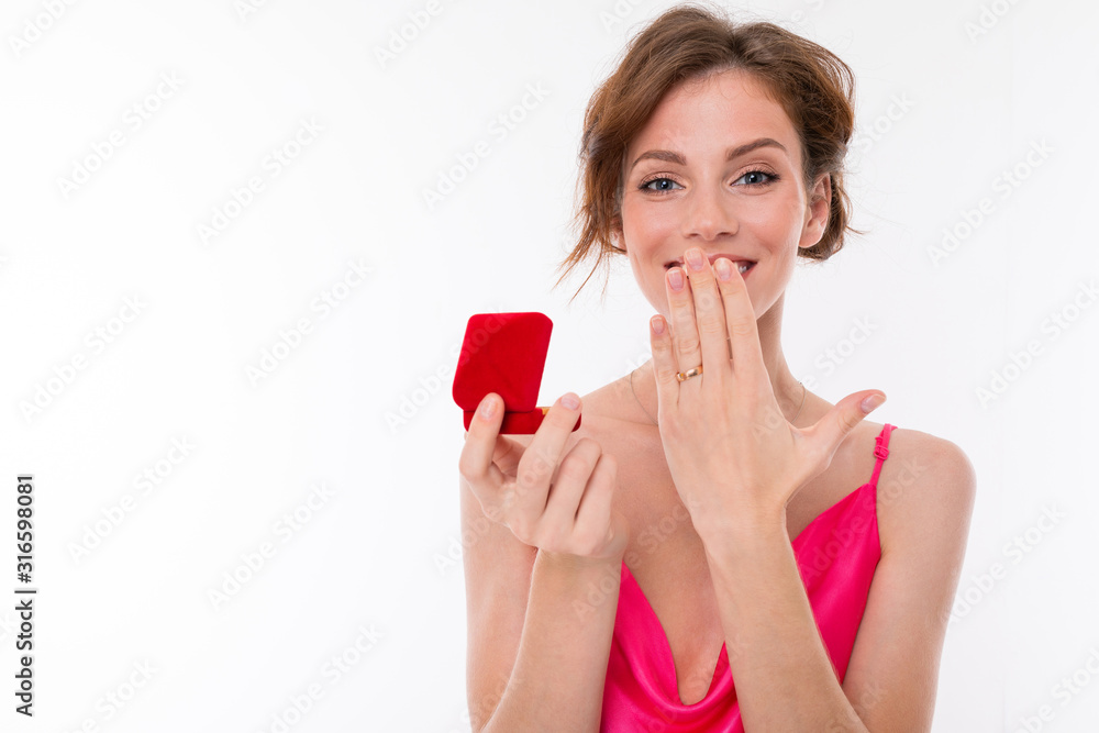 charming girl holds a box with a wedding ring on a white background charming girl holds a box with a wedding ring on a white background