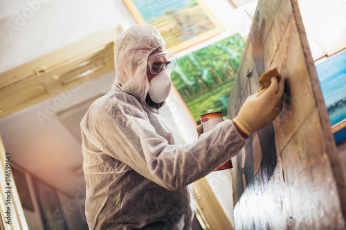Foto Restorer working on the painting at restoration workshop