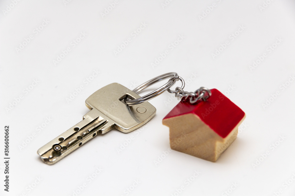 Schlüsselbund mit Schlüssel und Holz Haus Anhänger uaf weißem Hintergrund Schlüsselbund mit Schlüssel und Holz Haus Anhänger uaf weißem Hintergrund
