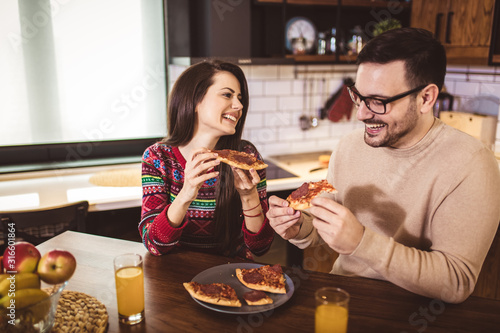 Wallpaper Mural Young couple enjoying eating pizza at home. Torontodigital.ca