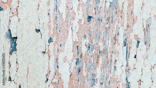 Flaking pink-blue paint on a faded wooden background