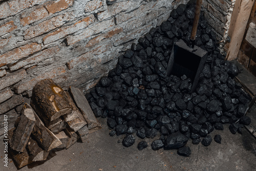 Obraz na plátně Coal, wood and shovel on the floor at the basement prepared for heating the house with