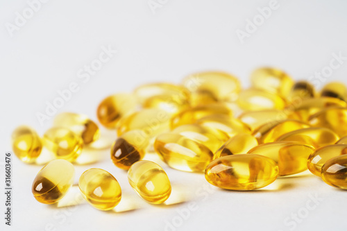 Omega 3 yellow pills on white background. EPA and DHA are two types of Omega-3 fats Essential Fatty Acids for healthy living.