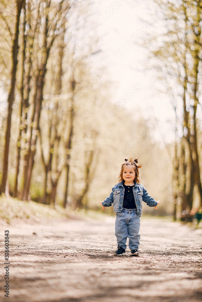 Beautiful little girl in a blue jacket. Child in a summer park Beautiful little girl in a blue jacket. Child in a summer park