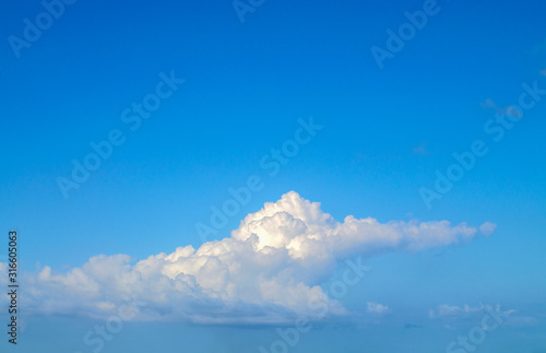 White fluffy cumulus cloud. Forked tongue. Blue sky © Сергей Михайлов