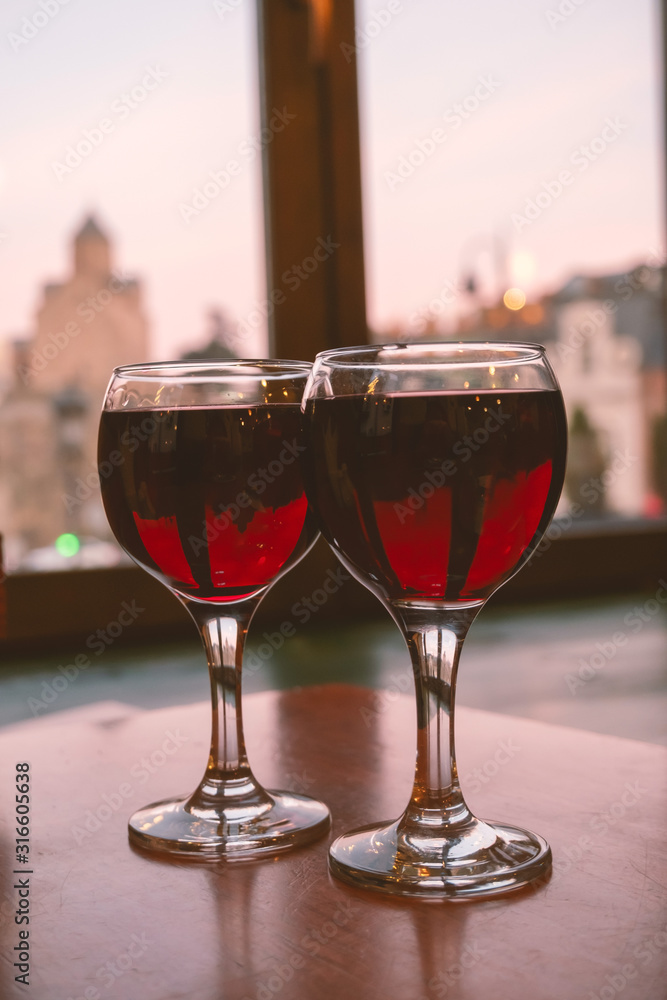 two glasses of red wine on the table in the restaurant, romantic dinner concept two glasses of red wine on the table in the restaurant, romantic dinner concept