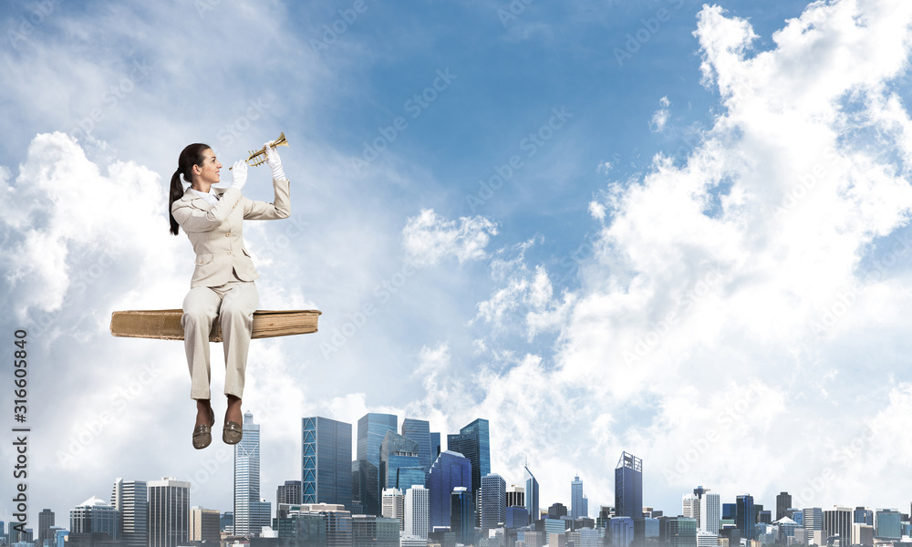 Elegant woman in business suit sitting on book Elegant woman in business suit sitting on book