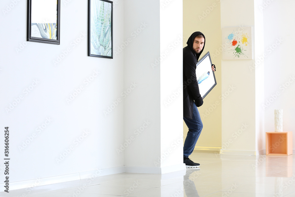 Thief stealing picture from art gallery Thief stealing picture from art gallery