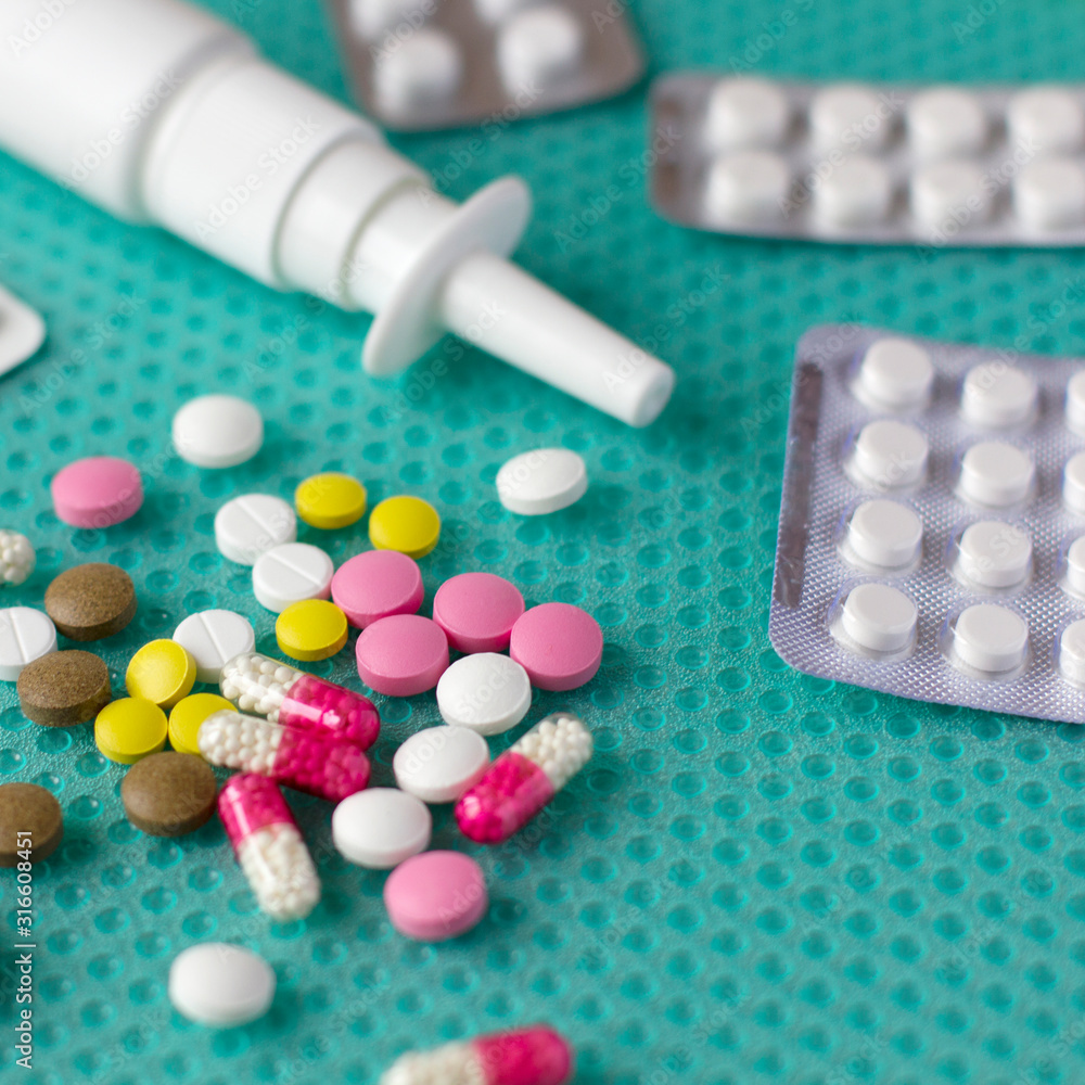 Multi-colored pills and a bottle with medicine on the table Multi-colored pills and a bottle with medicine on the table